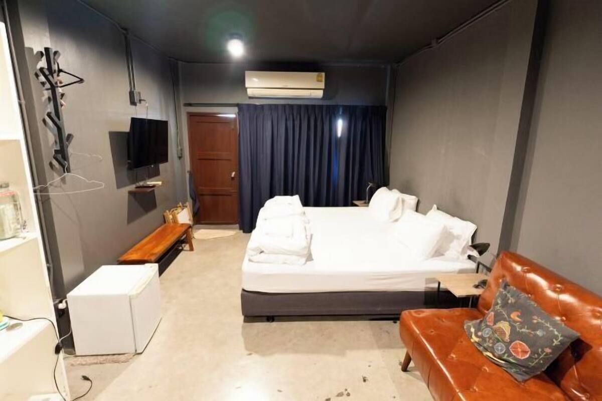 A hotel room with a bed, a TV, a desk, and a wardrobe.