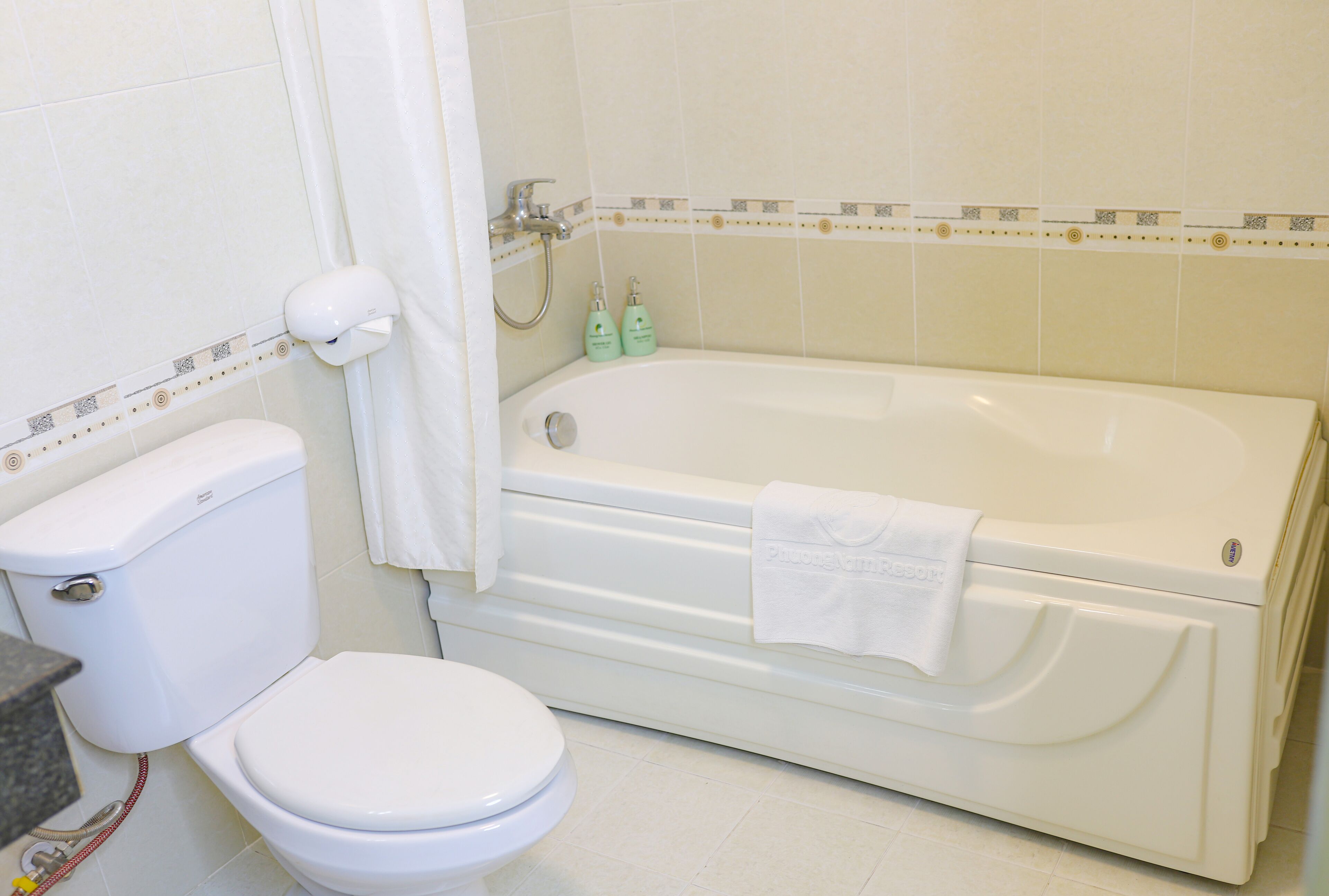A bathroom with a toilet, bathtub, and shower.