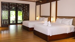 A hotel room with two beds, wooden flooring, a decorative wooden door, and a view through the door. - Phuong Nam Resort (Ho Chi Minh City)