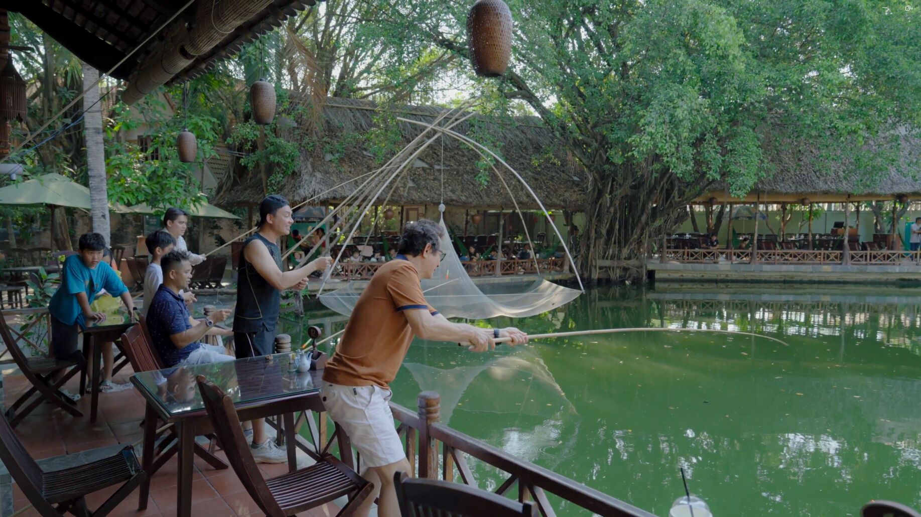 Un restaurante a orillas del río con terraza y vistas a un cuerpo de agua tranquilo.