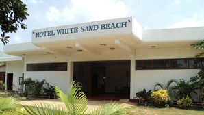 Een gebouw met een bord waarop staat: Hotel White Sand Beach.