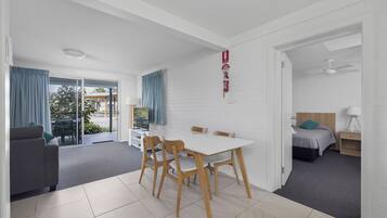 Une chambre moderne équipée d’une table à manger, de chaises, d’un canapé, d’un lit et d’un ventilateur de plafond.