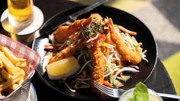 A plate of food with breaded shrimp and vegetables, a lemon wedge, and a mint leaf garnish.