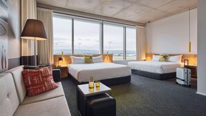 A hotel room with two beds, a sofa, a desk, and a suitcase. - Atura Adelaide Airport (Adelaide Airport)