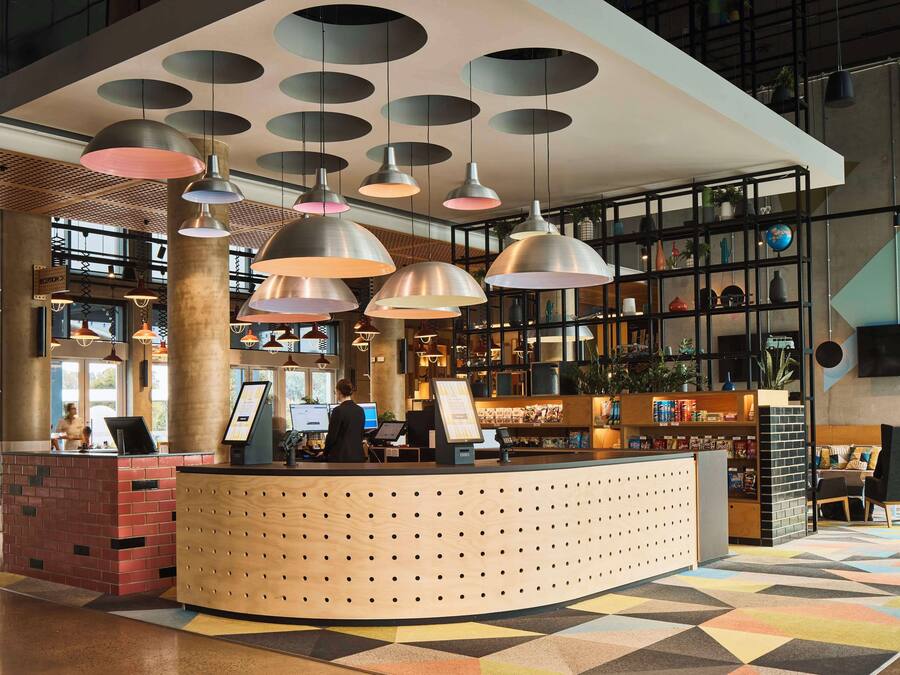 A modern reception area with a curved counter, multiple pendant lights, and a variety of decorative items on shelves.