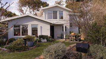 A two-story house with a front porch, a garage, and a well-maintained garden.