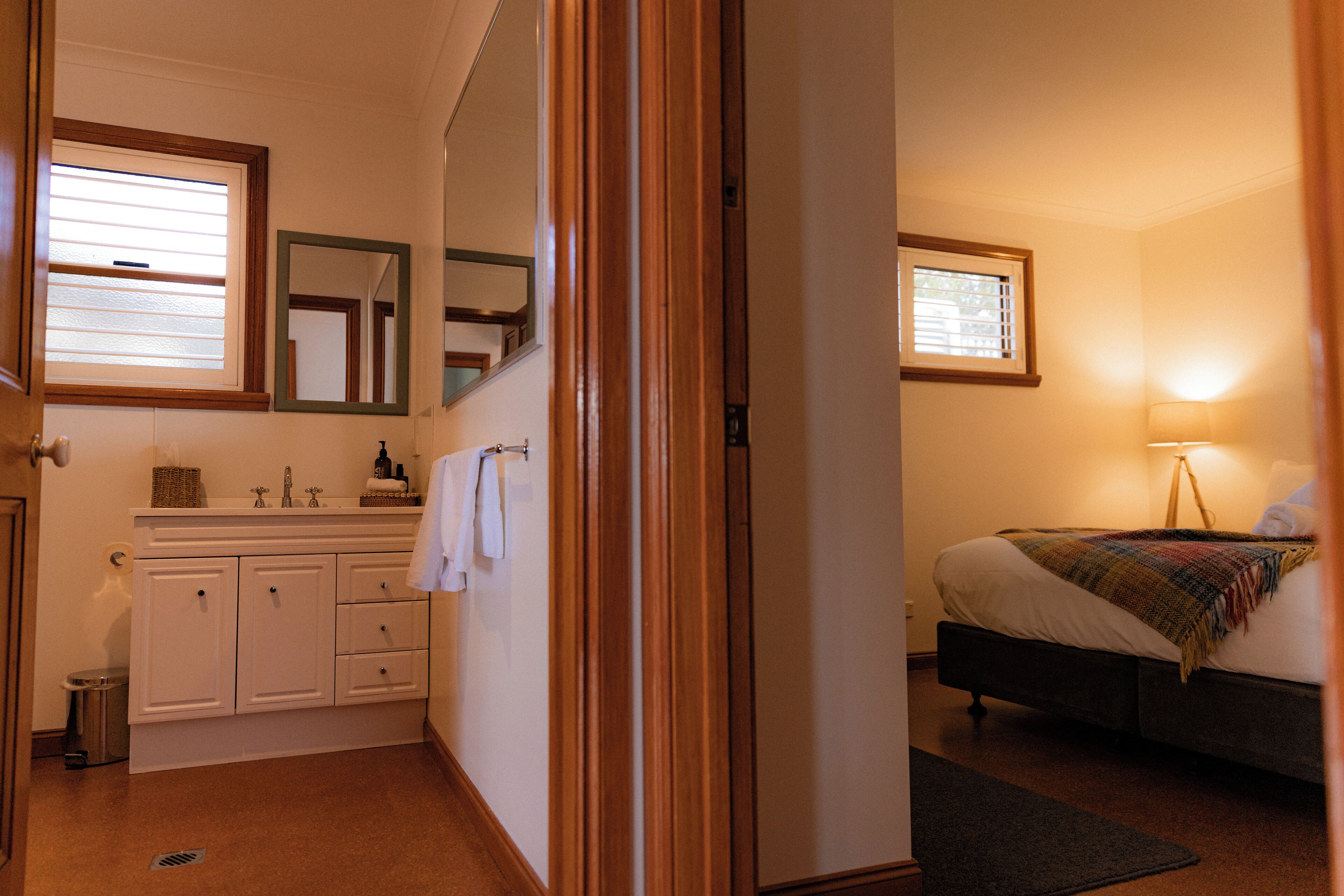 A bedroom with a bed, a bedside table, and a window.