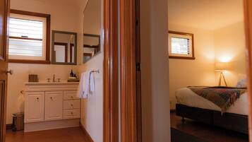 A bedroom with a bed, a bedside table, and a window.