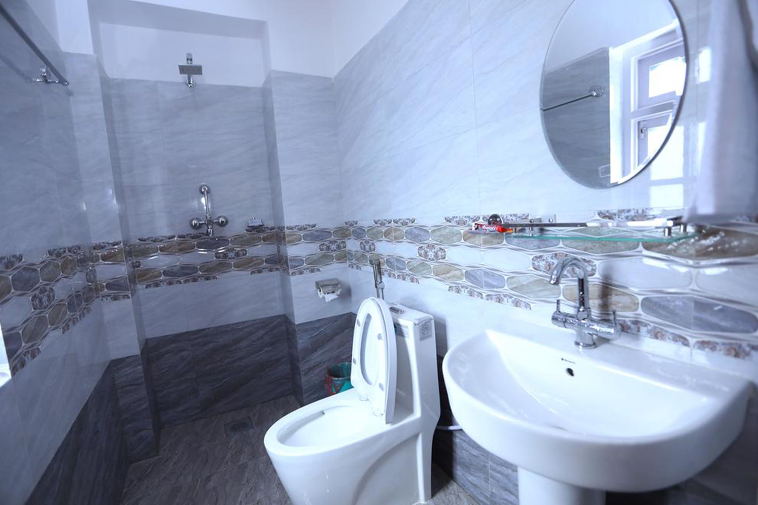 A bathroom with a toilet, sink, and shower.