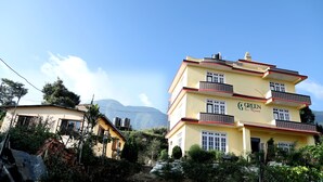 En bygning med flere etager, altaner og et skilt, der viser "GREEN Eco Resort".