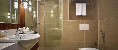 A modern bathroom with a glass-enclosed shower, a white sink, and a toilet.