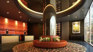 A lobby with a central circular seating area, a reception desk, and a wall with a clock display. - Cititel Express Penang (George Town)