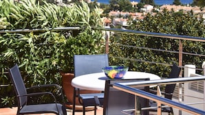 Una terrazza con tavolo e sedie, vista su una località costiera.