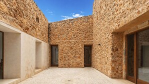 A courtyard with stone walls, a tiled floor, and two doors. - Wonderful private villa for 12 people with A/C, private pool, WIFI, TV, patio and panoramic view (Costitx)