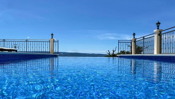 A clear blue infinity pool with a view of the horizon.