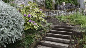 A stone staircase surrounded by lush greenery and flowering plants.