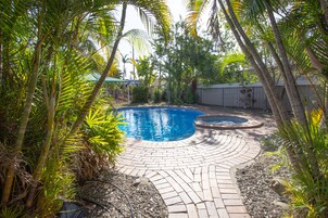 Una piscina al aire libre, sillones reclinables de piscina