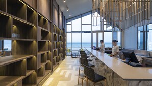 Een moderne bar met uitzicht op de oceaan, houten planken en een marmeren aanrecht.