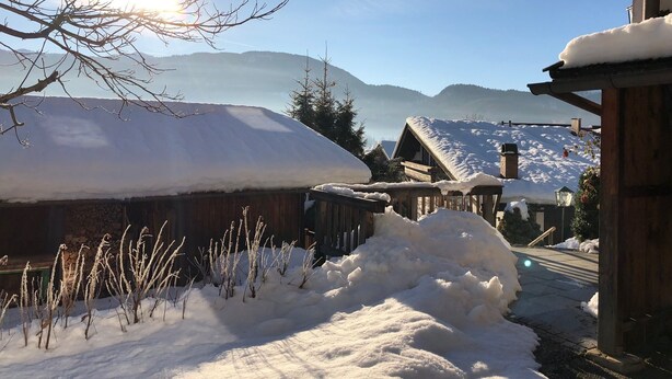 A snow-covered wooden building with a sloped roof, surrounded by snow and a clear sky. - Haus Dippold (Reit im Winkl)