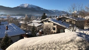 A snow-covered village with houses and a mountain in the background. - Haus Dippold (Reit im Winkl)