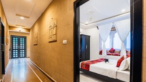 A hotel corridor with a bed in the room, a door, and a wall with a picture. - The Legend Haveli (Jaisalmer)