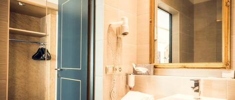 Un baño moderno con una puerta azul, un lavabo blanco, un espejo y un secador de pelo en la pared.