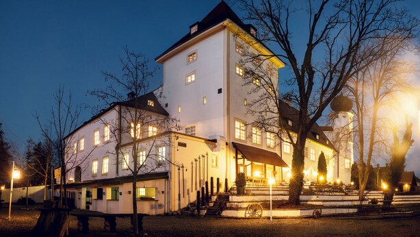 A large, multi-story building with a symmetrical facade, multiple windows, and a central entrance. - Schlosshotel Neufahrn (Neufahrn in Niederbayern)