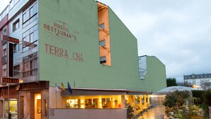 A building with a sign for "Restaurante Terra Cha" and a restaurant interior visible through the windows. - Hostal Terra Chá (Villalba)