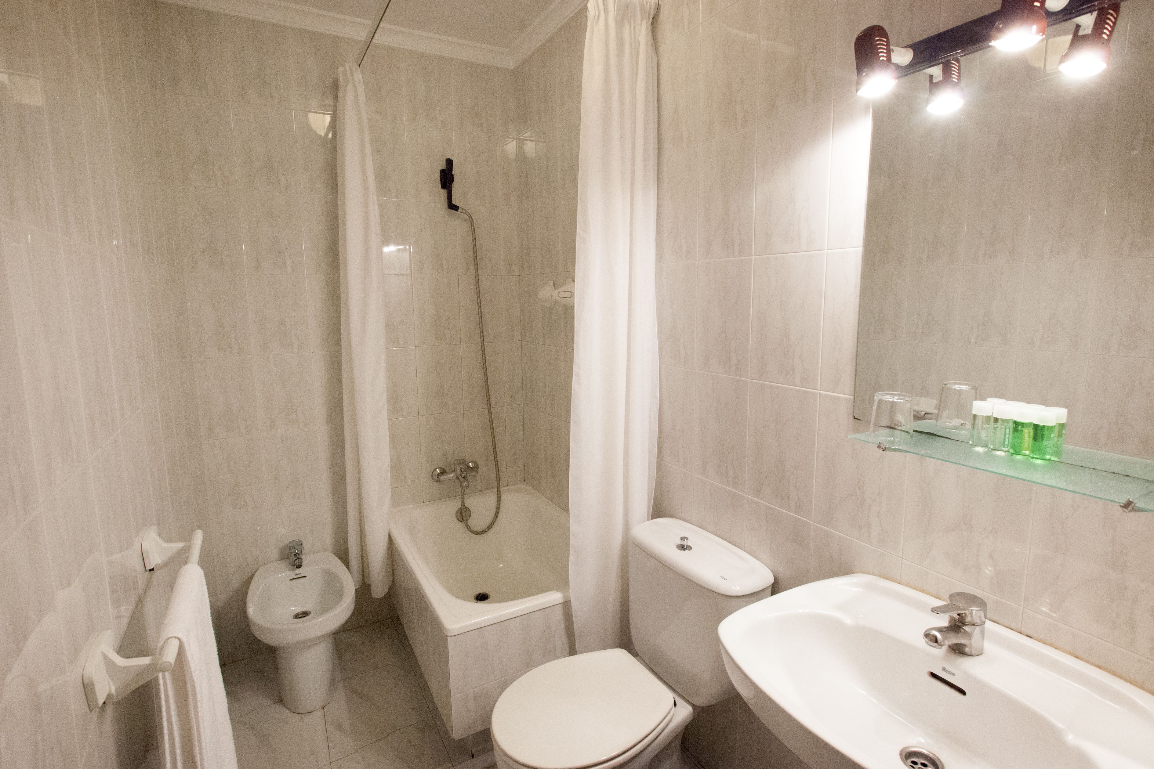 Un baño con bañera, inodoro, bidé y lavamanos.