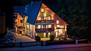 A multi-story hotel with balconies and a lit sign indicating a restaurant. - KRISTINA Willa & Spa (Szklarska Poreba)