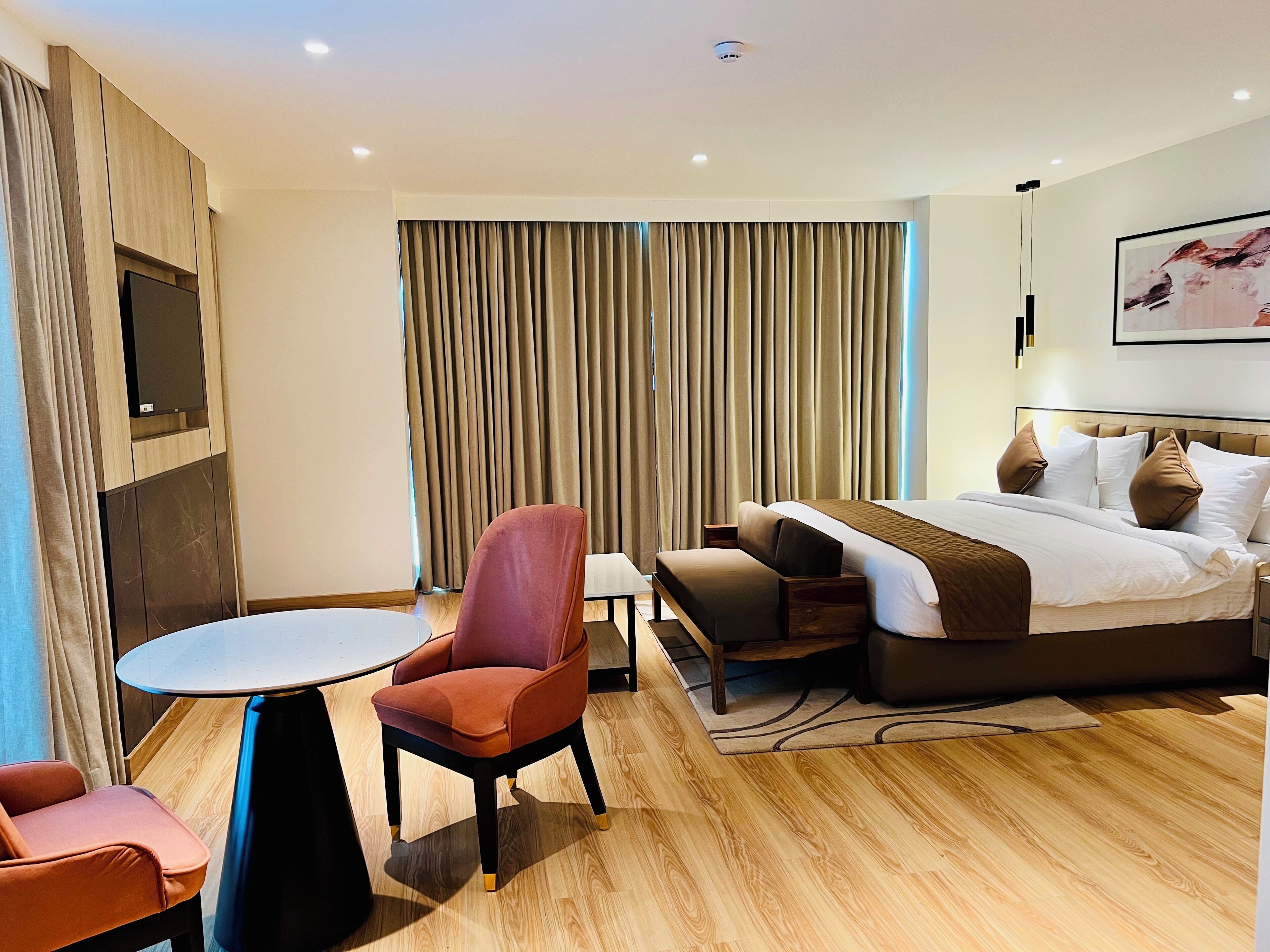Una habitación de hotel moderna con cama, escritorio, silla y televisor.
