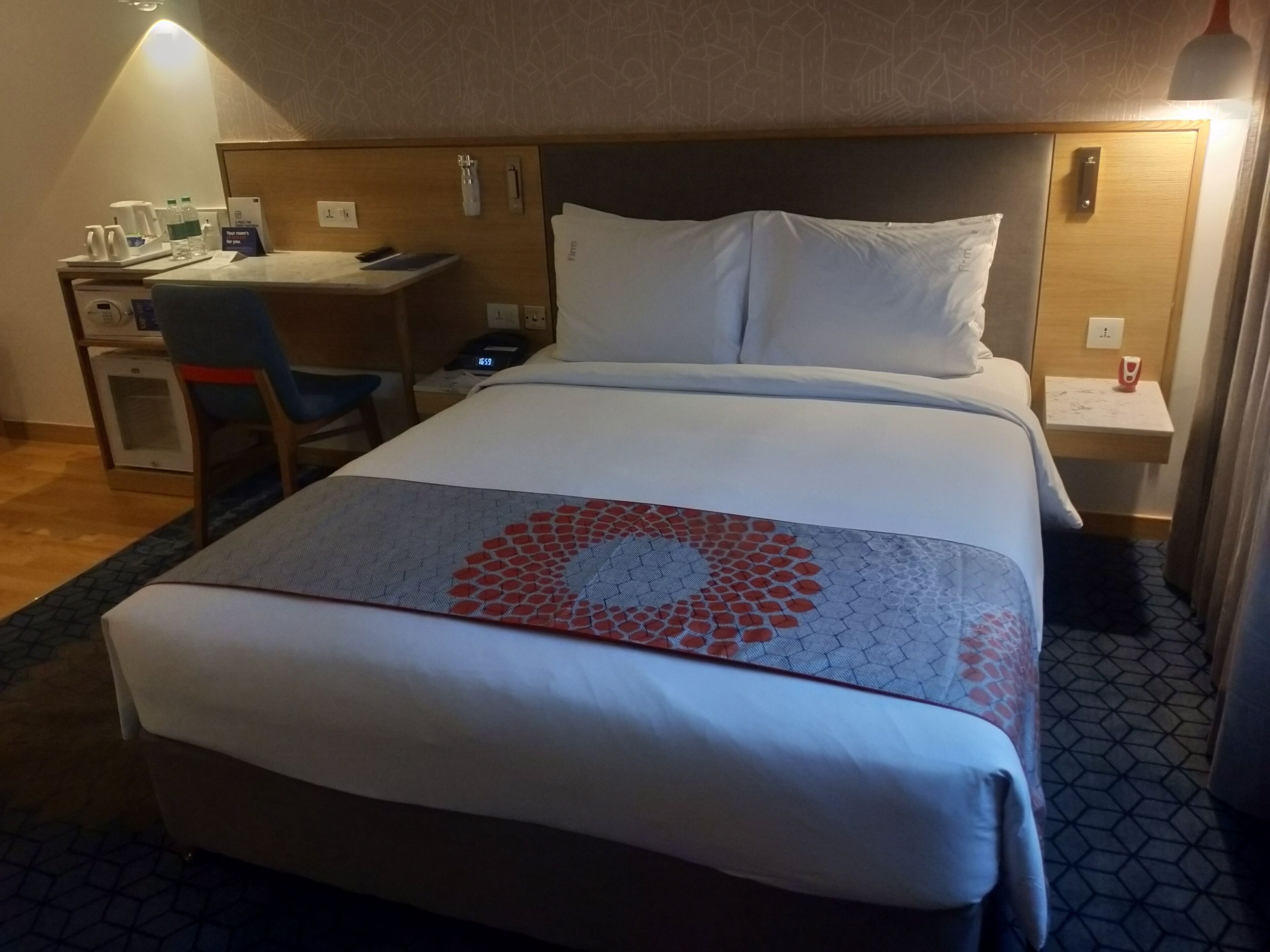 Une chambre d’hôtel avec un lit, un bureau, une chaise et une petite table.