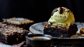 Un postre con helado y un hilo de chocolate sobre un plato.