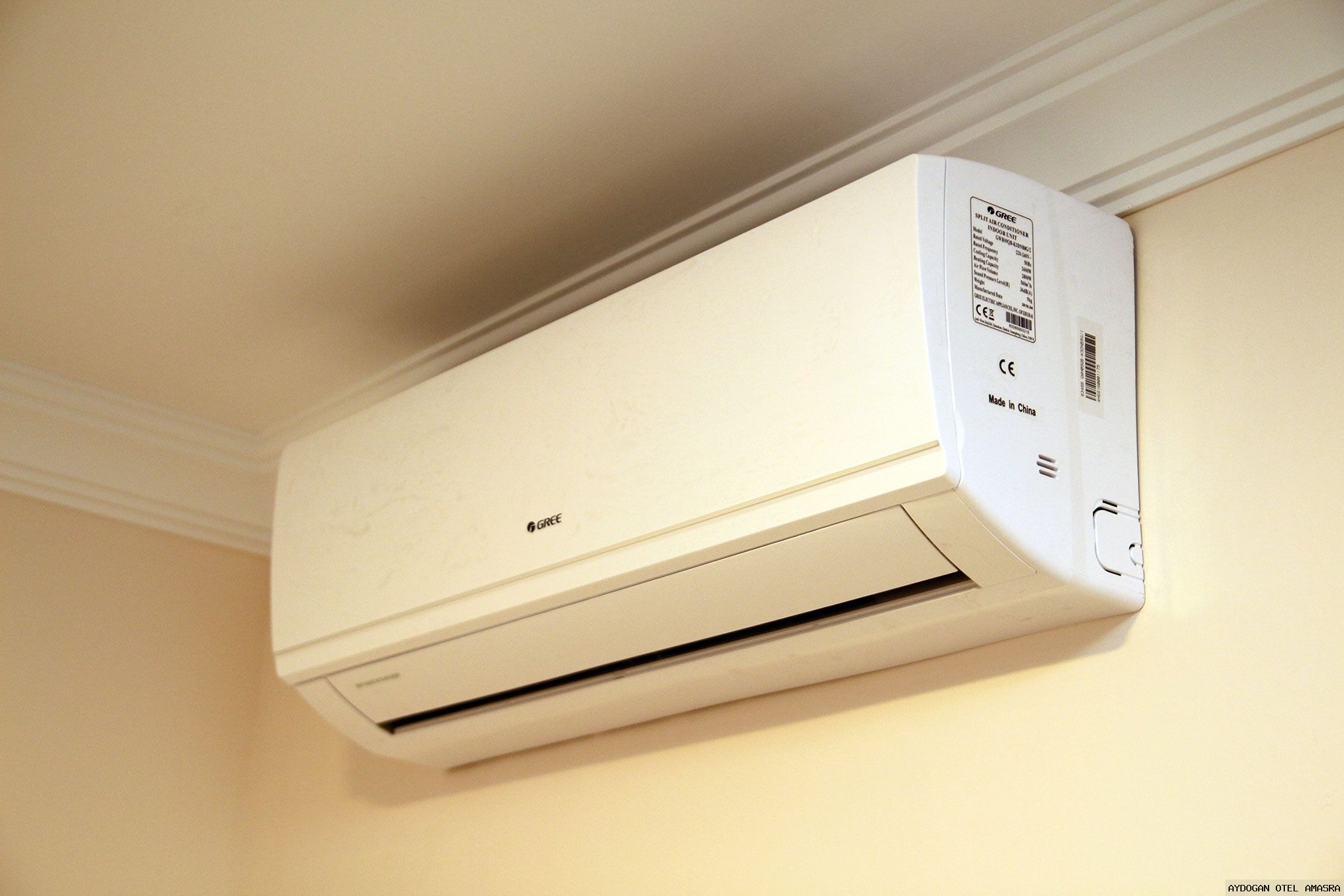 A white wall-mounted air conditioner with a brand label and a CE mark indicating it is made in China.