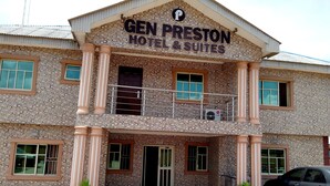A hotel with a patterned facade, a balcony, and a car parked in front. - Gen-Preston Hotel & Suites (Papalanto)
