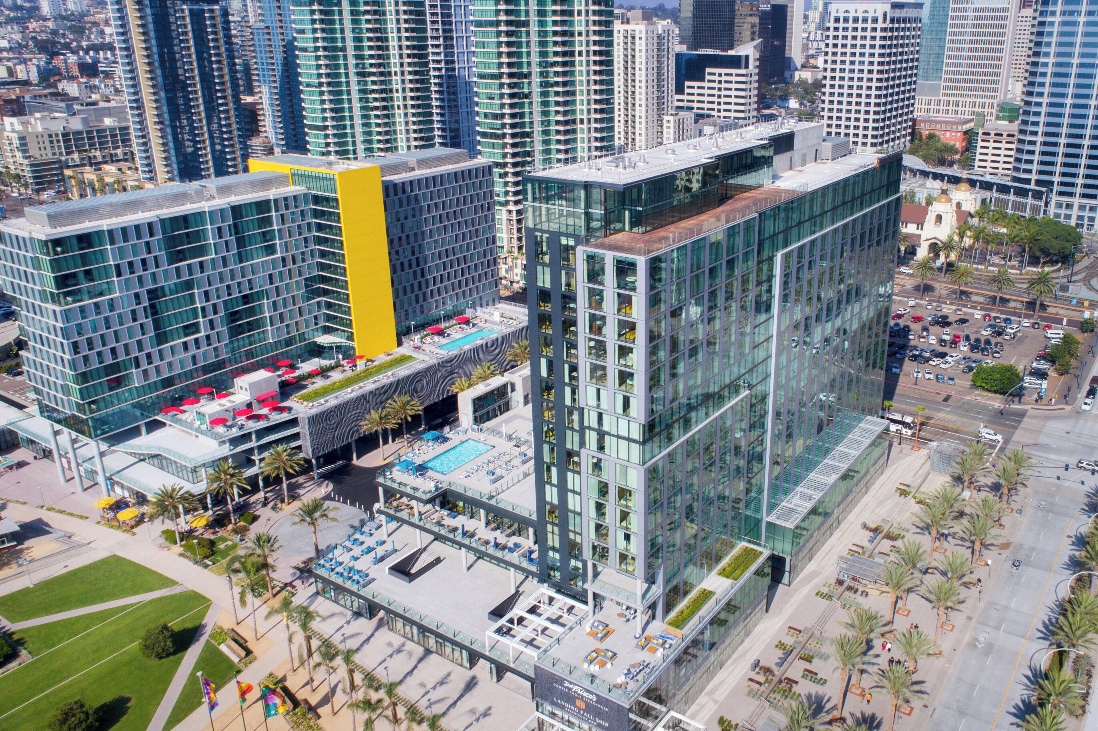 A high-rise building with a rooftop pool and outdoor seating area.