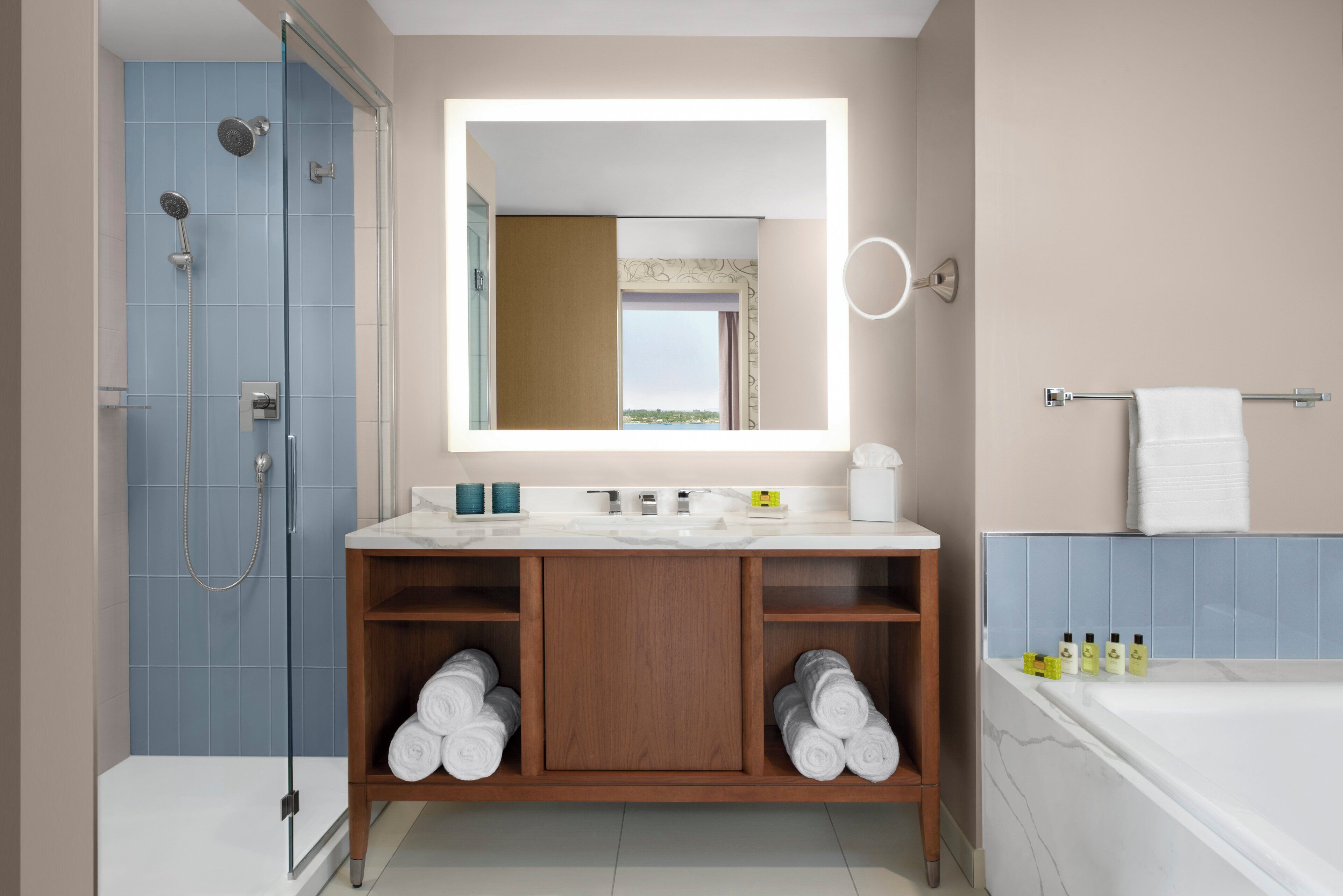 Ein modernes Badezimmer mit Duschkabine aus Glas, Waschtisch mit Spiegel und einer Badewanne.