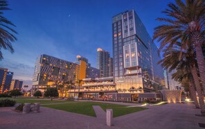 A modern hotel with multiple floors, a central atrium, and a landscaped courtyard with palm trees. - InterContinental San Diego by IHG (San Diego)