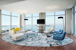A modern living room with a large window, a flat-screen TV, and a view of the city. - InterContinental San Diego by IHG (San Diego)