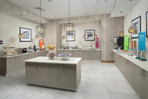 A modern kitchen with a central island, various appliances, and hanging pendant lights. - Hampton Inn Marathon - Florida Keys (Marathon)
