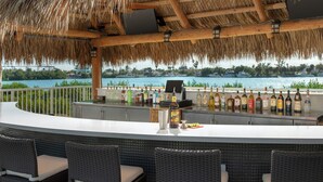 A bar with a view of the water, wicker chairs, and a thatched roof. - Hampton Inn Marathon - Florida Keys (Marathon)