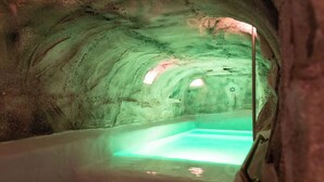 An ice cave with a central pool and a viewing area.