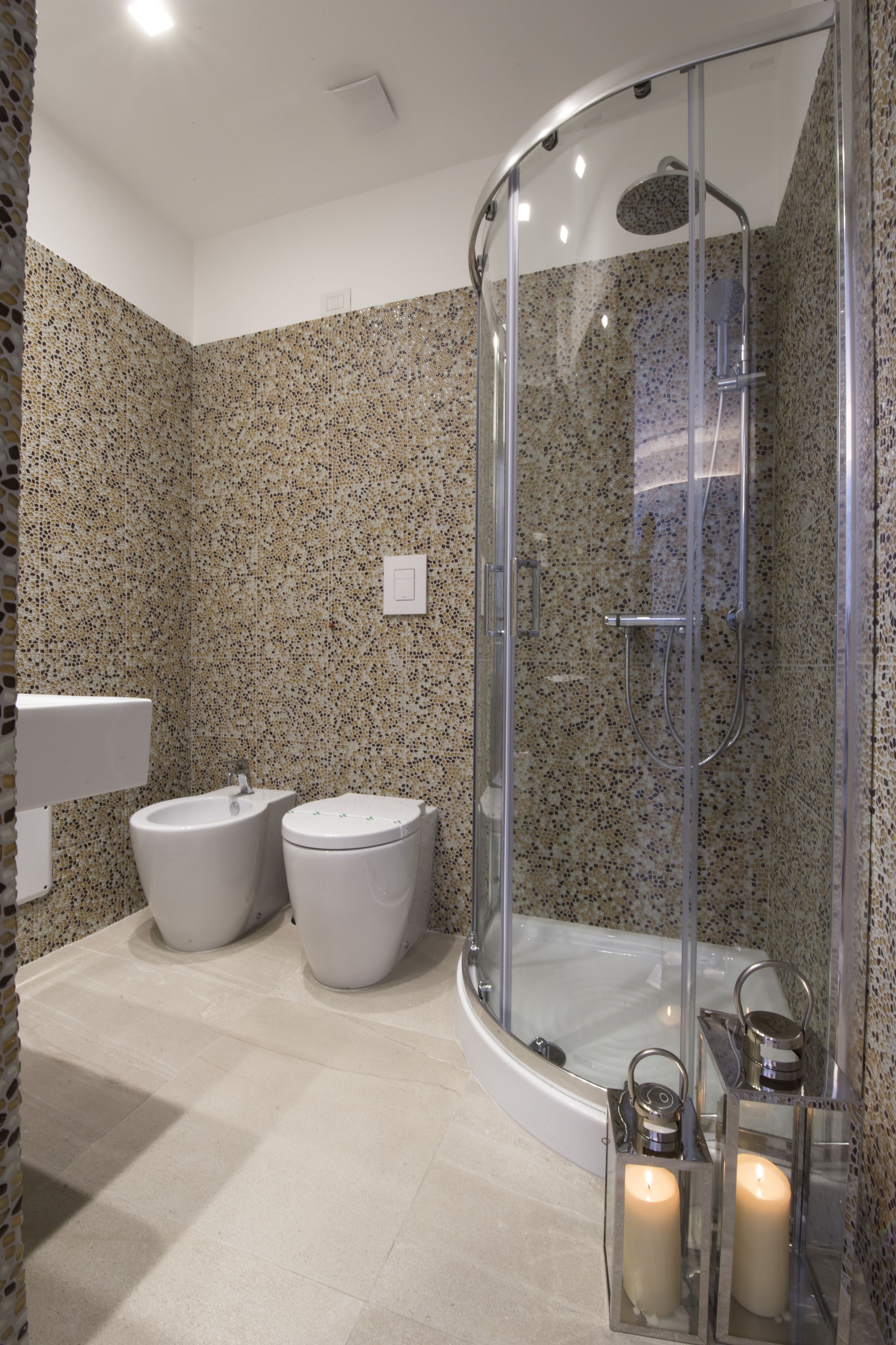Un baño moderno con ducha envuelta en vidrio, bañera independiente y dos inodoros.