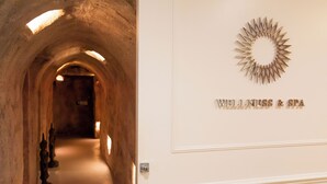 A corridor with a stone archway leading to a room labeled "WELLNESS & SPA".