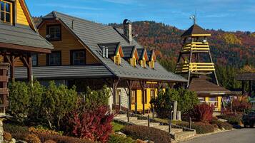 A lodge with a prominent chimney, a bell tower, and a stone fireplace.