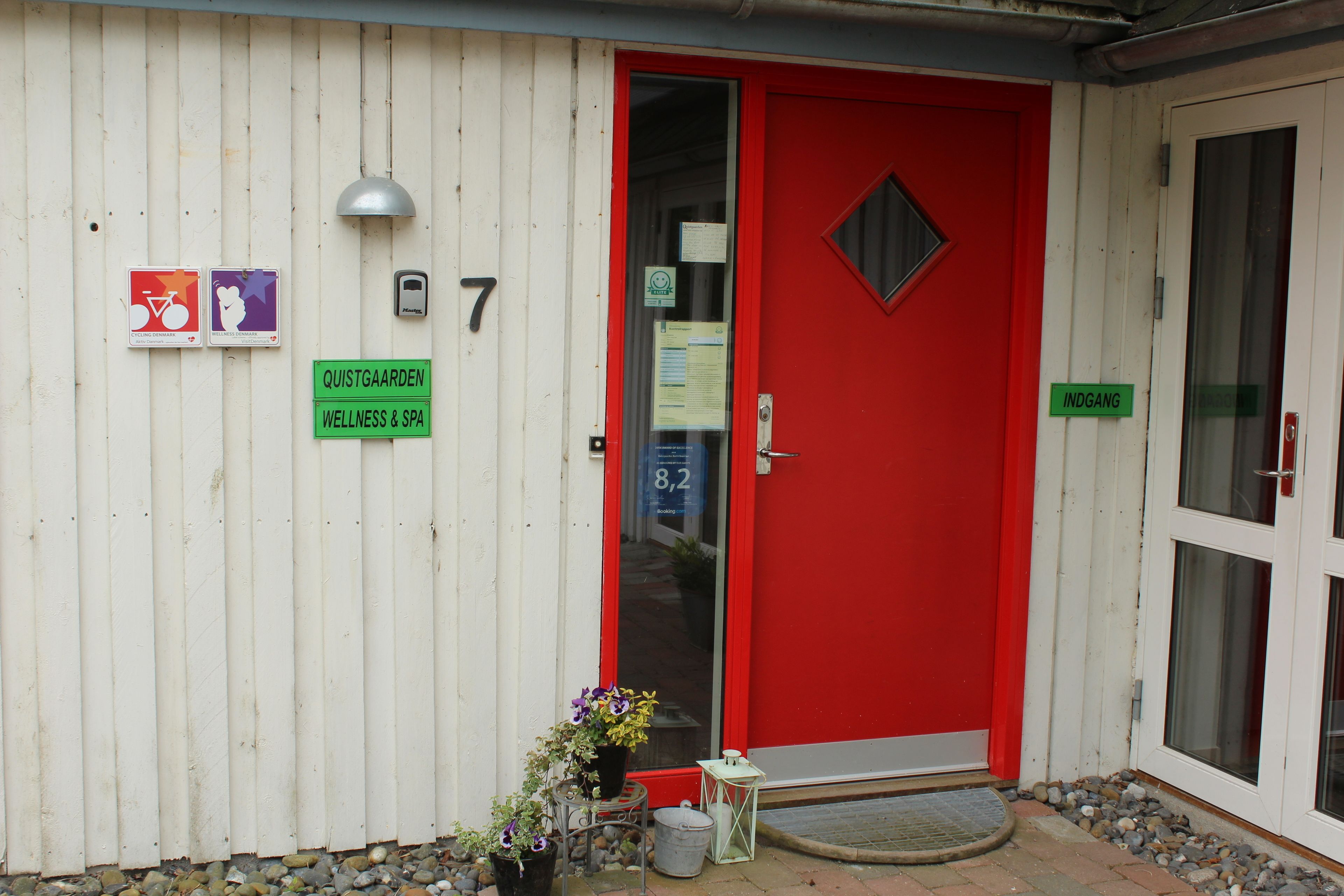 A building with a red door, numbered 7, and signs indicating wellness and spa services.