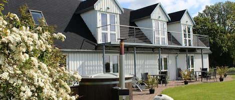 Un bâtiment à deux étages doté d’un balcon, d’un jacuzzi et où l’on peut voir un chien sur la pelouse.