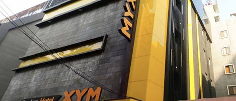 A modern building with a sign reading "Design Hotel XYM."