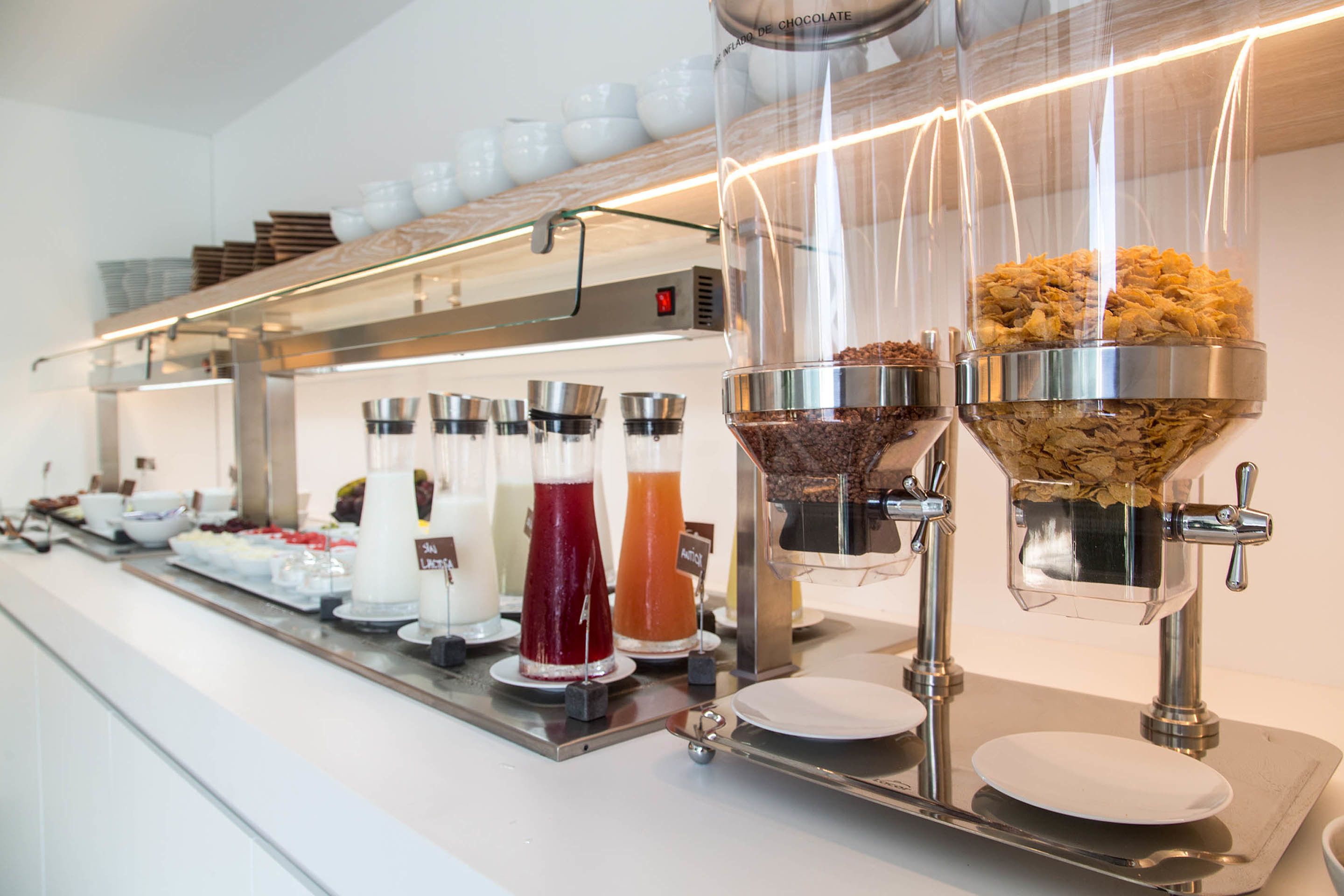 Una barra de buffet con diversos alimentos y bebidas.