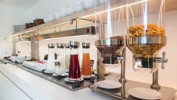 Una barra de buffet con diversos alimentos y bebidas.
